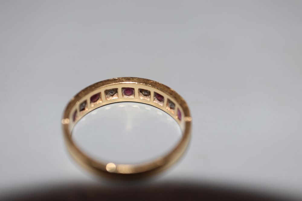 A modern 18ct gold, ruby and diamond set nine stone half hoop ring, size M, gross 3.2 grams.